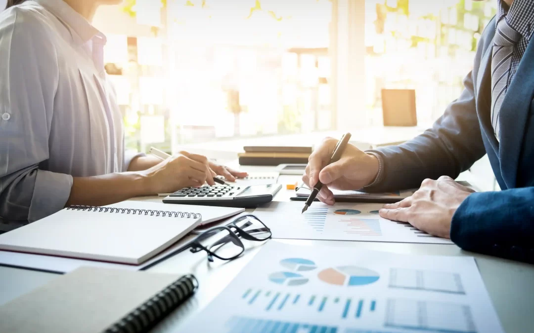 Two professionals reviewing financial charts and tax data during a business consultation, representing Auditnet's tax planning services in Cyprus