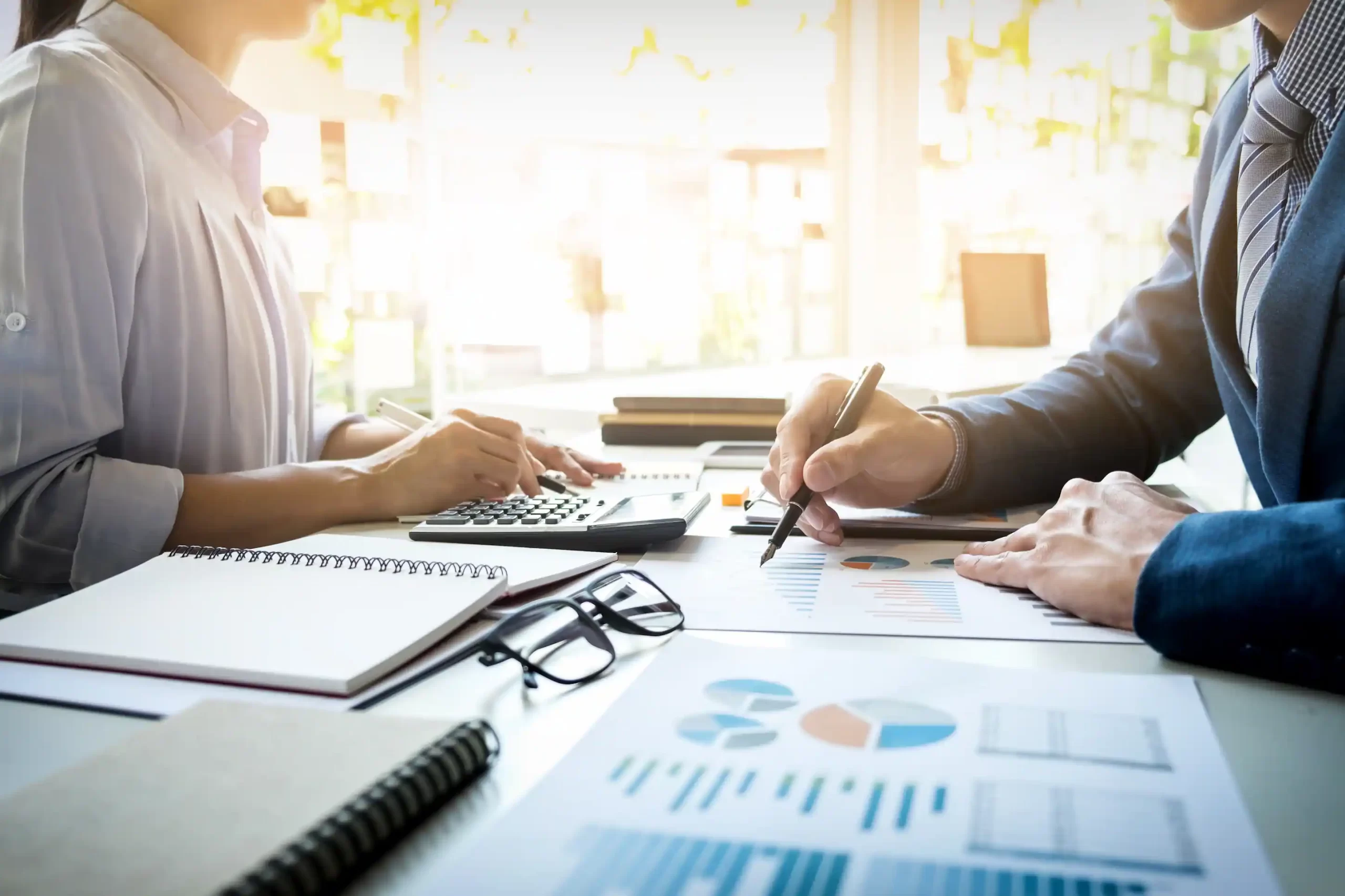 Two professionals reviewing financial charts and tax data during a business consultation, representing Auditnet's tax planning services in Cyprus